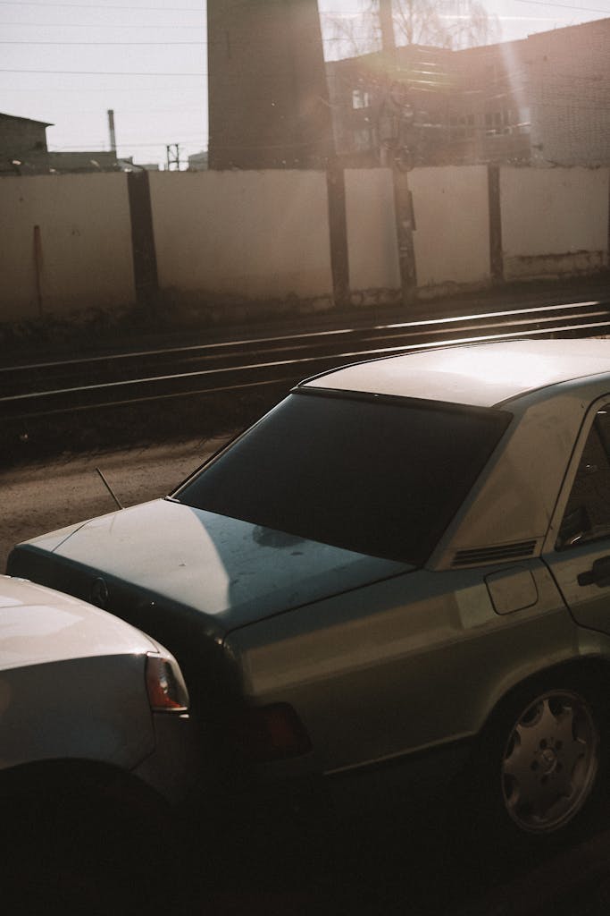 Close-up of two vehicles in a minor fender bender near railroad tracks.
