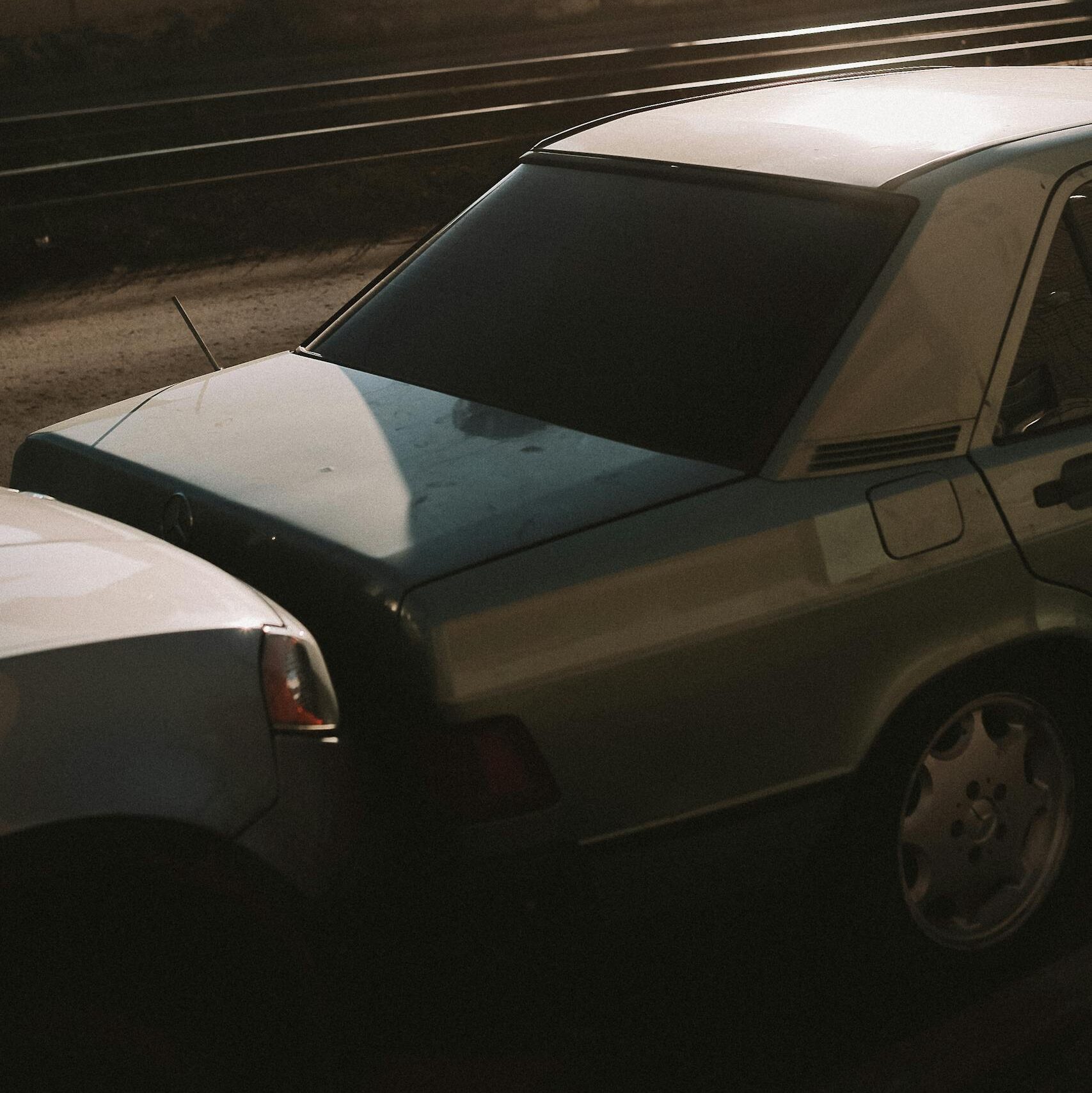 Close-up of two vehicles in a minor fender bender near railroad tracks.